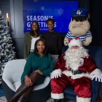 Mom with teenage kids smiles with Santa and Louie
